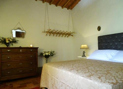 a bedroom with a white bed and a dresser and a bed sidx sidx sidx at Podere Pievina Delle Corti - Dimora di Campagna in Sinalunga