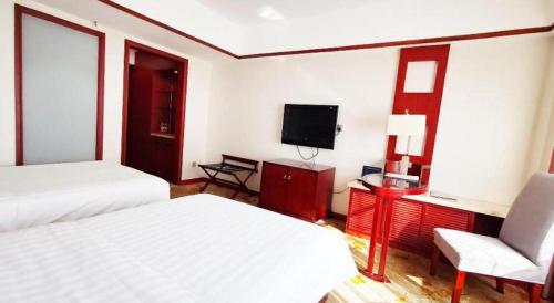 a hotel room with two beds and a television at Starmoon Hotel in Beijing