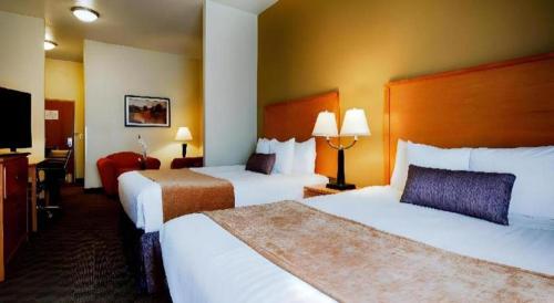 a hotel room with two beds and a flat screen tv at Best Western Plus Guymon Hotel and Suites in Guymon