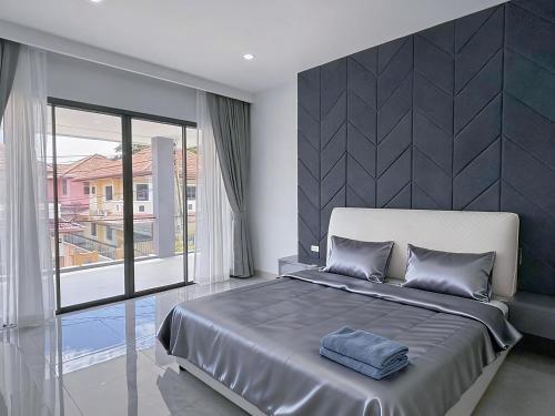 a bedroom with a large bed and a large window at 泰国芭提雅别墅 近中天海滩泳池别墅 in Jomtien Beach