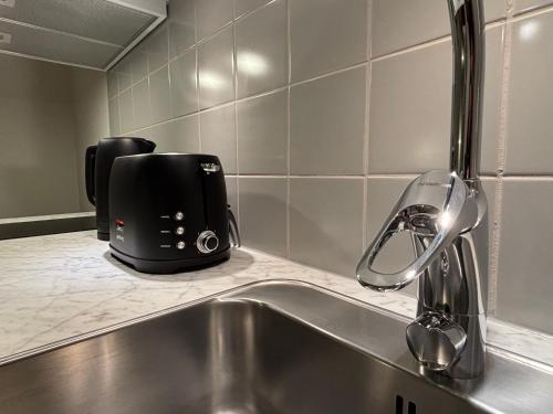 einen Toaster, der auf einer Theke neben einem Waschbecken sitzt in der Unterkunft Forenom Aparthotel Luleå Västra Stranden in Luleå