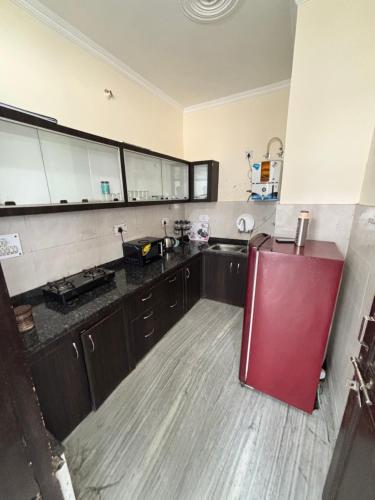 a large kitchen with a red refrigerator in it at NATURE EMBRACE NEAR GANGEs in Rishīkesh