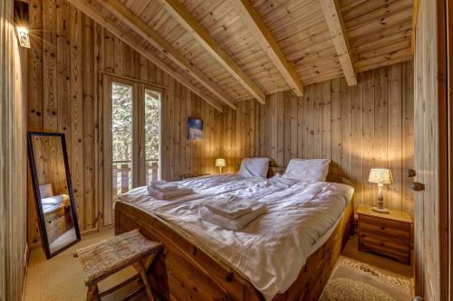 a bedroom with a large bed in a log cabin at Chalet Brunello in La Tzoumaz