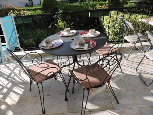 a black table and chairs with cups and saucers at Belvedere Montargis Amilly in Amilly