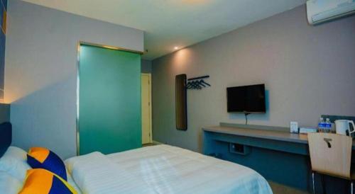 a room with a bed and a tv on a wall at 7 Days Inn Xi'an Railway Station in Xi'an