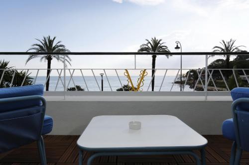 a table and chairs with a view of the ocean at Hotel Victoria in Roquebrune-Cap-Martin