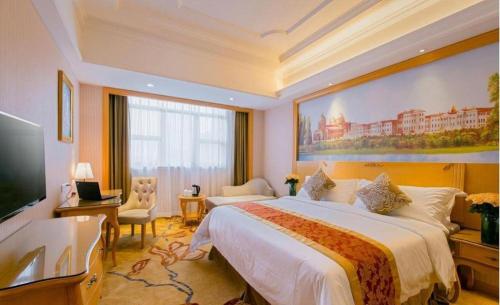 a hotel room with a large bed and a television at Vienna International Shenzhen Tianan Digital City in Shenzhen