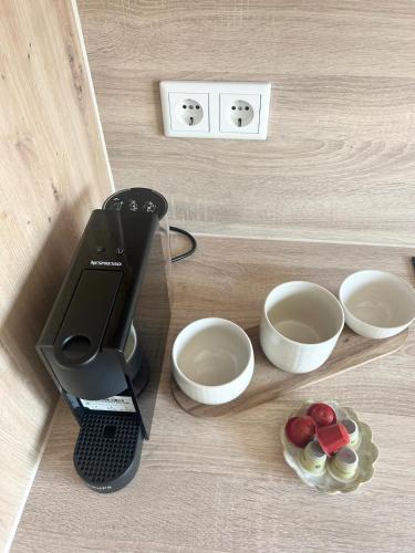 a black juicer sitting on a counter next to bowls at Laubushof - Idyllisches Apartment im Grünen mit Balkon in Villmar