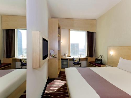 a hotel room with a bed and a desk at ibis Sharq in Kuwait