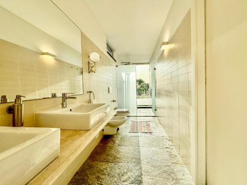 ein weißes Badezimmer mit zwei Waschbecken und einer Toilette in der Unterkunft Casas do Moinho, Alentejo Country House in Santa Margarida da Serra