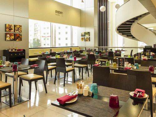 a dining room with tables and chairs in a restaurant at ibis Sharq in Kuwait