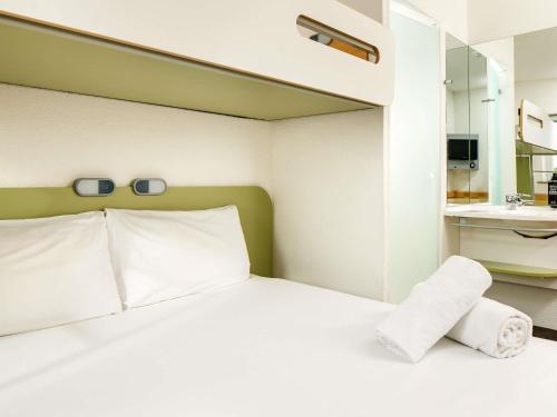 a bedroom with a white bed and a sink at ibis budget Sheffield Arena in Sheffield
