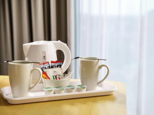 a tea kettle and cups on a tray on a table at ibis Nottingham Centre in Nottingham