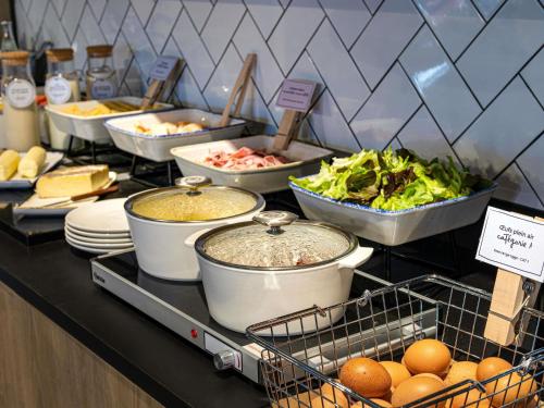 a buffet with many dishes of food on a table at ibis Bordeaux Centre Bastide in Bordeaux