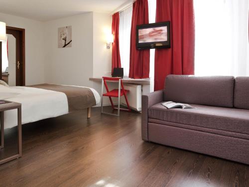 a hotel room with a bed and a couch at Mercure Biel in Biel