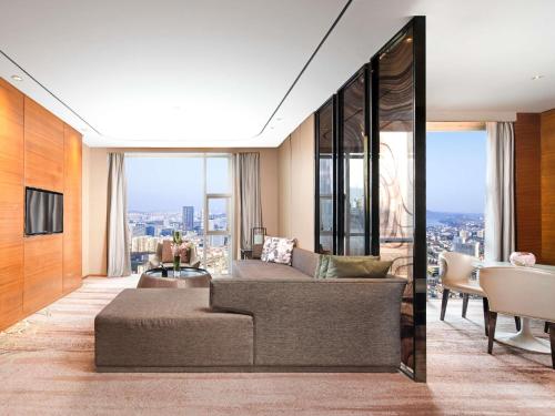 a living room with a couch and a tv at Sofitel Nanjing Galaxy in Nanjing