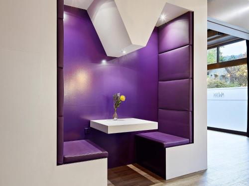 a room with purple walls and purple stools at Mercure Biel in Biel