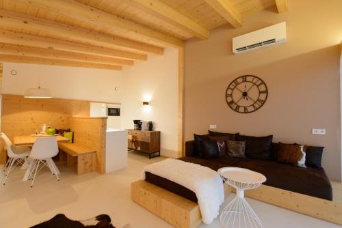 a bedroom with a bed and a table with a clock on the wall at Moar Lodge in Postal