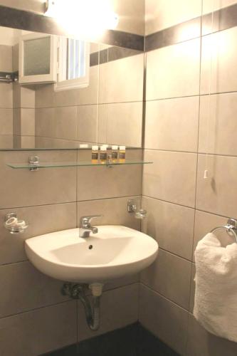a bathroom with a white sink and a mirror at Diavlos Studios in Agiokampos