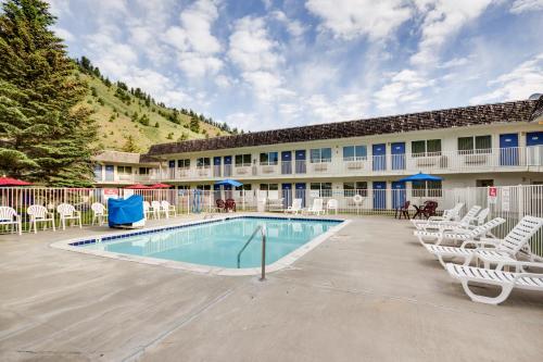 a resort with a swimming pool and chairs and a building at The Jackson SouthTown Motel in Jackson