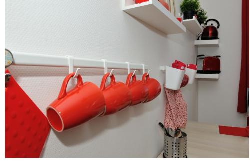 a row of red rubber boots hanging on a wall at Appart Cosy Brest (La gare) vue mer in Brest