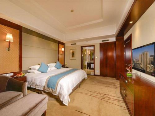 a hotel room with a bed and a television at Gaosu New Century Hotel International Anhui in Hefei