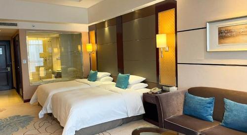 a large hotel room with two beds and a couch at Gaosu New Century Hotel International Anhui in Hefei