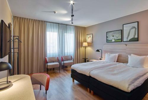 a hotel room with a large bed in a room at Scandic Borlänge in Borlänge