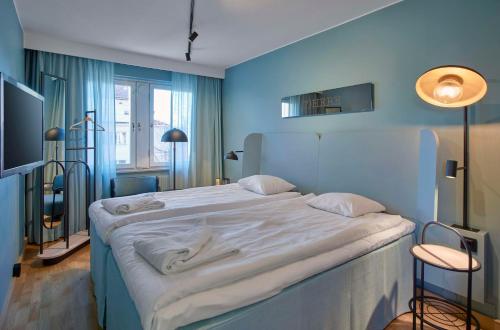 a bedroom with a large bed in a blue room at Scandic Borlänge in Borlänge
