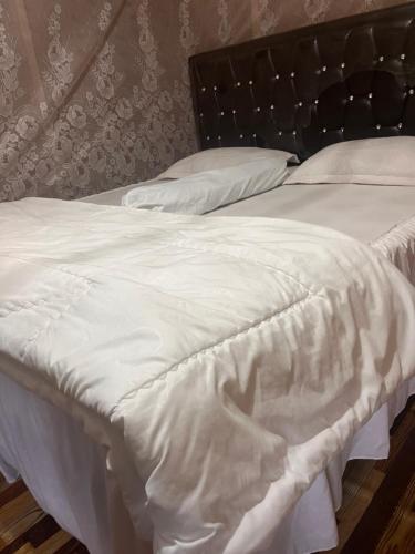 a white bed with white sheets and pillows at Cinta alam inn in Kutacane
