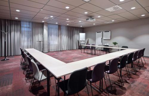 a conference room with a long table and chairs at Scandic Borlänge in Borlänge