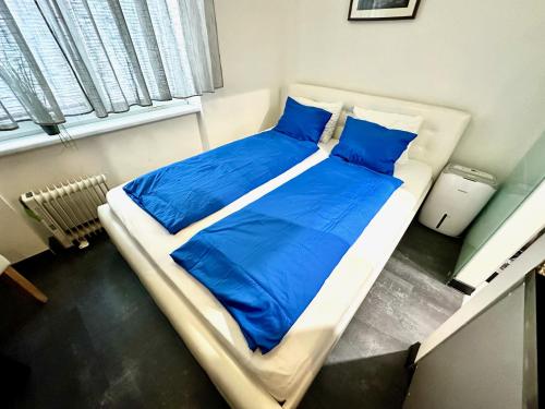 a bed with blue sheets and pillows in a room at 24 hour-Self Check-in Apartment Námestie Svätého Egídia in Poprad