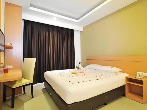a bedroom with a bed and a desk and a chair at Guest House Nozz in Semarang