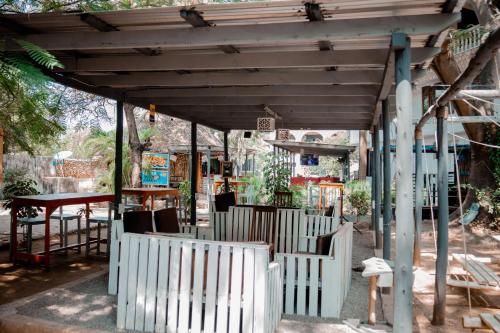 a white wooden pergola with a table and chairs at Hotel & Apartment Serene in Dar es Salaam