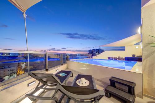 a balcony with a pool and a table and chairs at D Top View in St. Paul's Bay