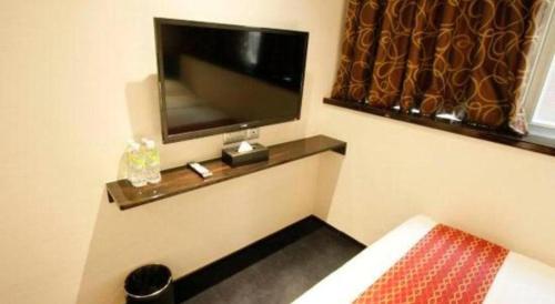 a room with a flat screen tv on a wall at Noble Park Hotel in Hong Kong