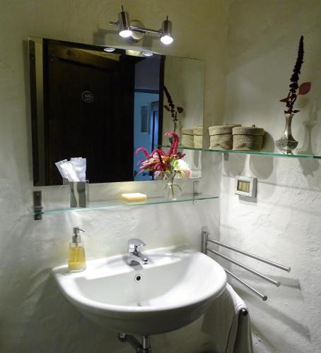 a bathroom with a white sink and a mirror at Podere Pievina Delle Corti - Dimora di Campagna in Sinalunga