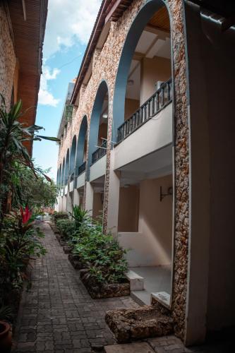 an alley with a building with an archway and plants at Hotel & Apartment Serene in Dar es Salaam