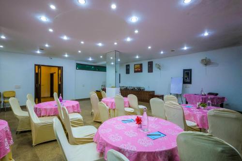 a room with pink tables and chairs with pink tablecloths at Nikko Blue - Boutique Hotel in Gurgaon