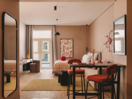 a room with a bed and a table and chairs at Saint J Hotel by Brassbell in Cairo