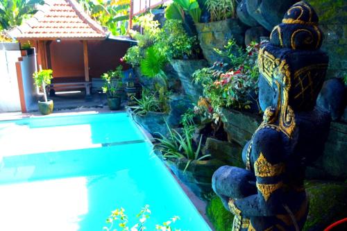 a garden with a swimming pool and a stone wall at Dahlia Moon Villa in Saba