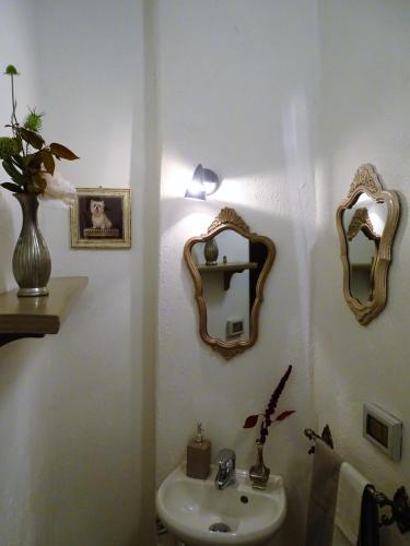 a bathroom with a sink and mirrors on the wall at Podere Pievina Delle Corti - Dimora di Campagna in Sinalunga