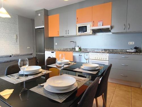 una cucina con tavolo da pranzo, sedie e bicchieri di Sun&Sand Cotillo a Cotillo