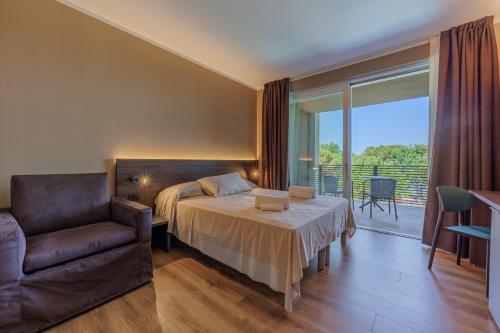 a bedroom with a bed and a chair and a balcony at Hotel San Marco in Bardolino