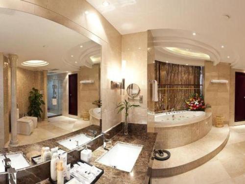 a large bathroom with a large tub and a large sink at Bliss International Hotel Weihai in Weihai