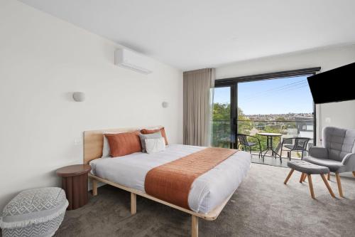 a bedroom with a bed and a balcony at Iona Ave Suites I Geelong Accommodation I regionalXscapes in Belmont