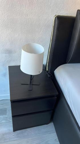 a lamp on a night stand next to a bed at Fewo Fischer am Bischenberg in Sasbachwalden
