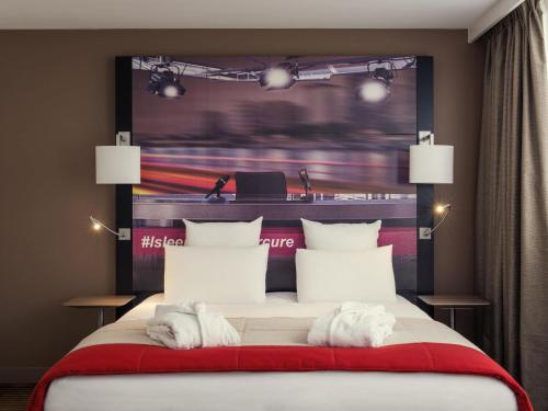 a bedroom with a bed with white towels on it at Mercure Paris Boulogne in Boulogne-Billancourt