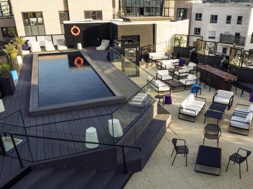 a rooftop patio with a swimming pool on a building at Mercure Paris Boulogne in Boulogne-Billancourt