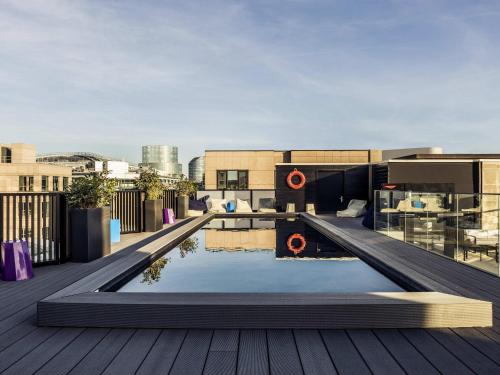 a rooftop patio with a pool on a building at Mercure Paris Boulogne in Boulogne-Billancourt